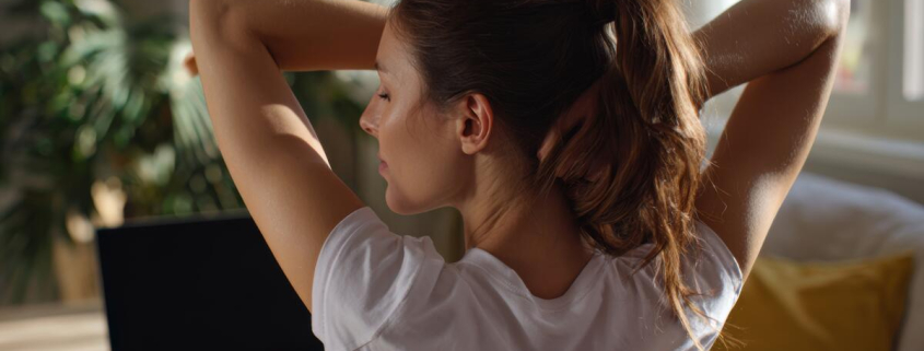 woman stretching at home office as part of a holistic approach to pain relief