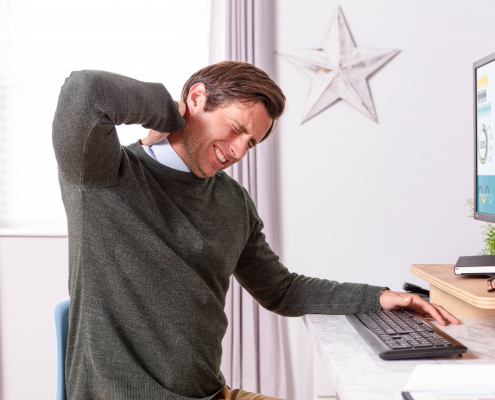 young man lower back ache relief due to poor desk posture