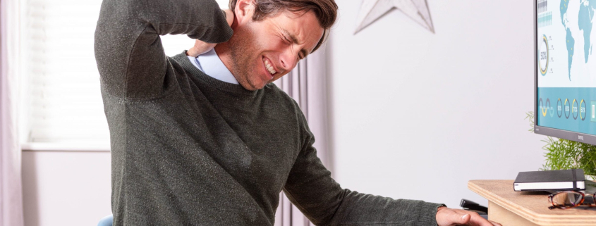 young man lower back ache relief due to poor desk posture