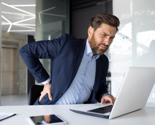 businessman his office with shoulder pain where back stretcher is helpful