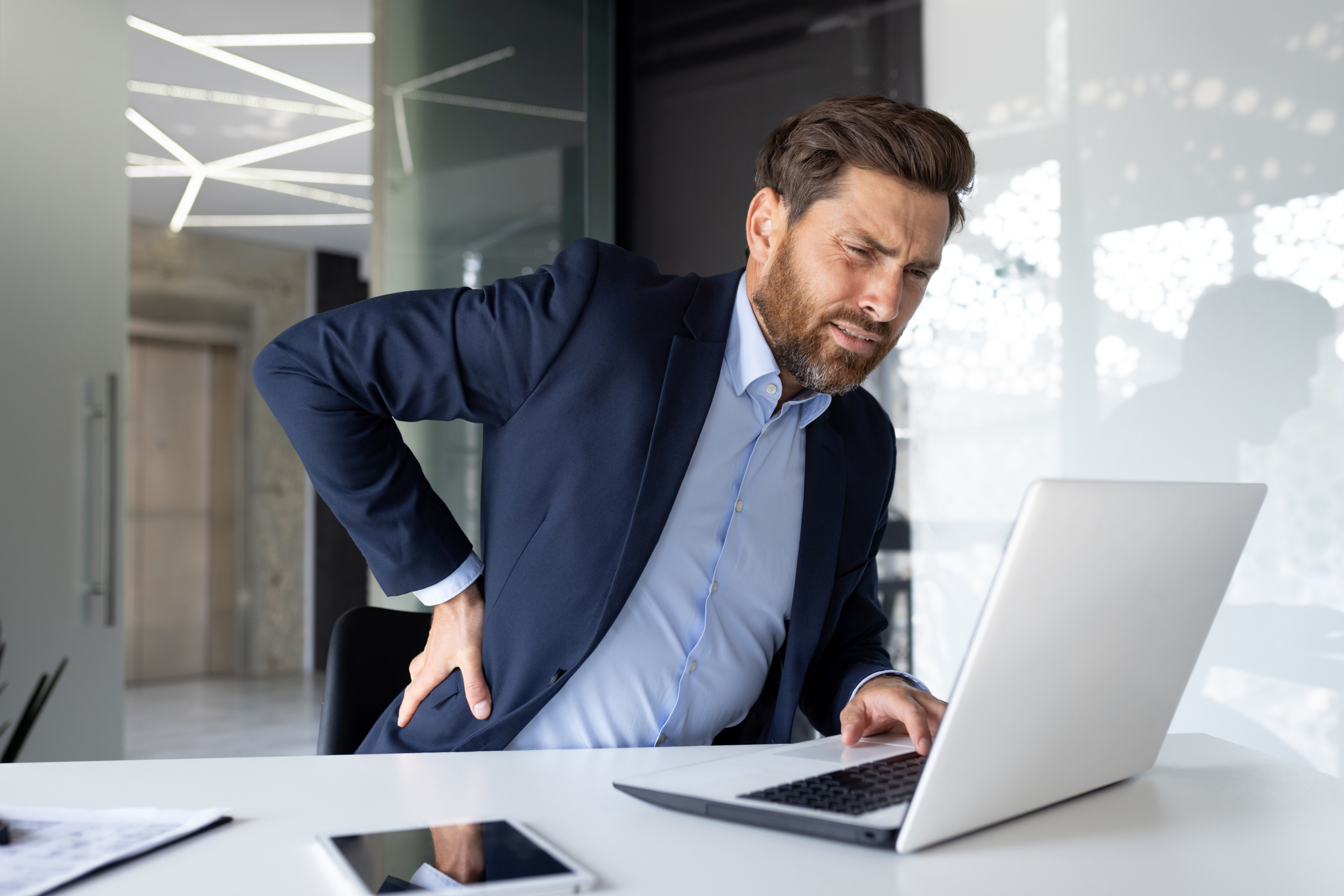 businessman his office with shoulder pain where back stretcher is helpful