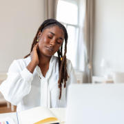 businesswoman experiencing back of neck aches after sitting at desk
