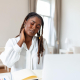 businesswoman experiencing back of neck aches after sitting at desk