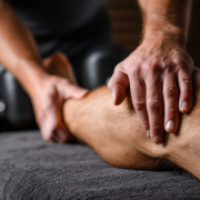 sore muscle relief - man holding sore leg muscles after workout