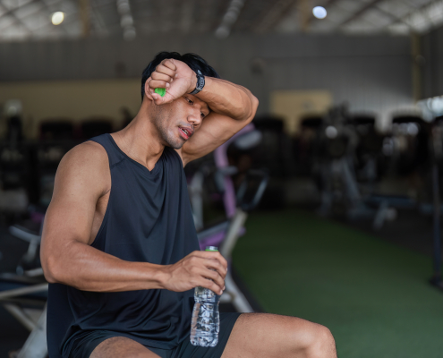 soreness after workout - athlete stretching sore muscles during post workout recovery