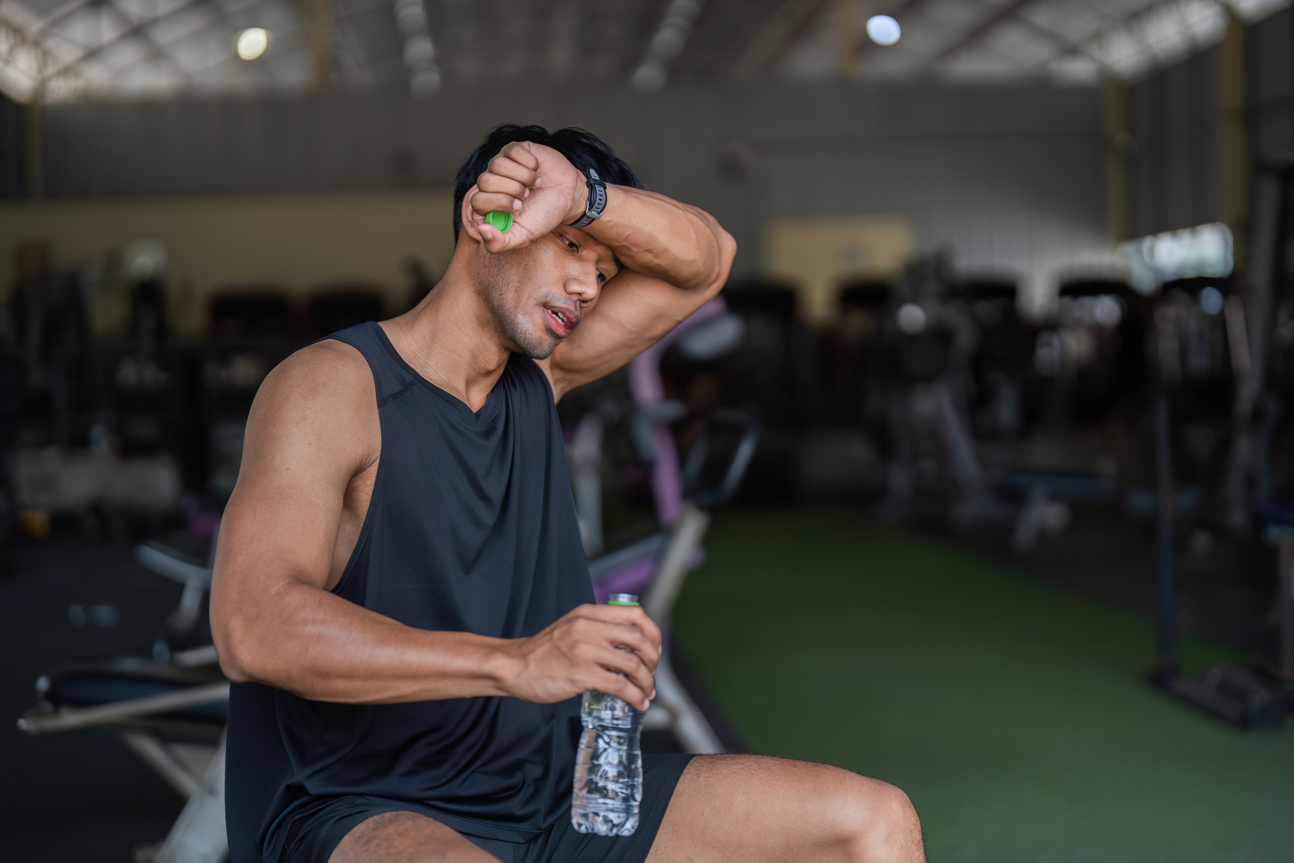 soreness after workout - athlete stretching sore muscles during post workout recovery