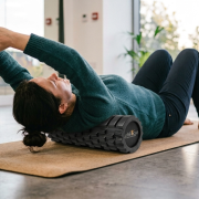 Person lying on floor with back roller balls beneath the shoulder blades for thoracic mobility work