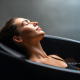 Woman tracking her safe ice bath duration in an outdoor cold water therapy pod to optimize muscle recovery