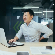asian businessman working in office having lower back ache symptoms