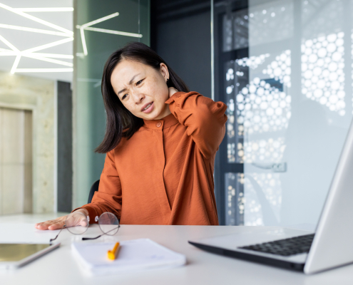 Person experiencing neck cramping while working at a desk