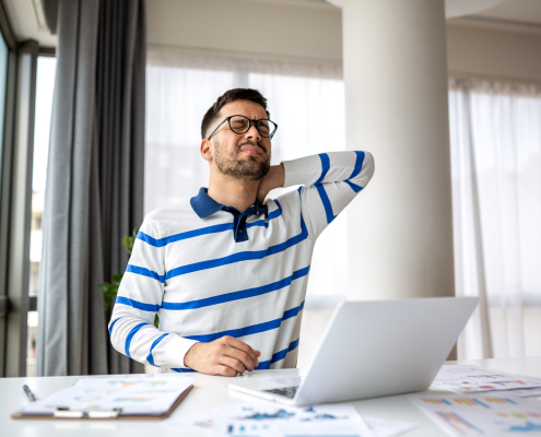 Man doing Self-Massage on her neck and shoulders at her desk