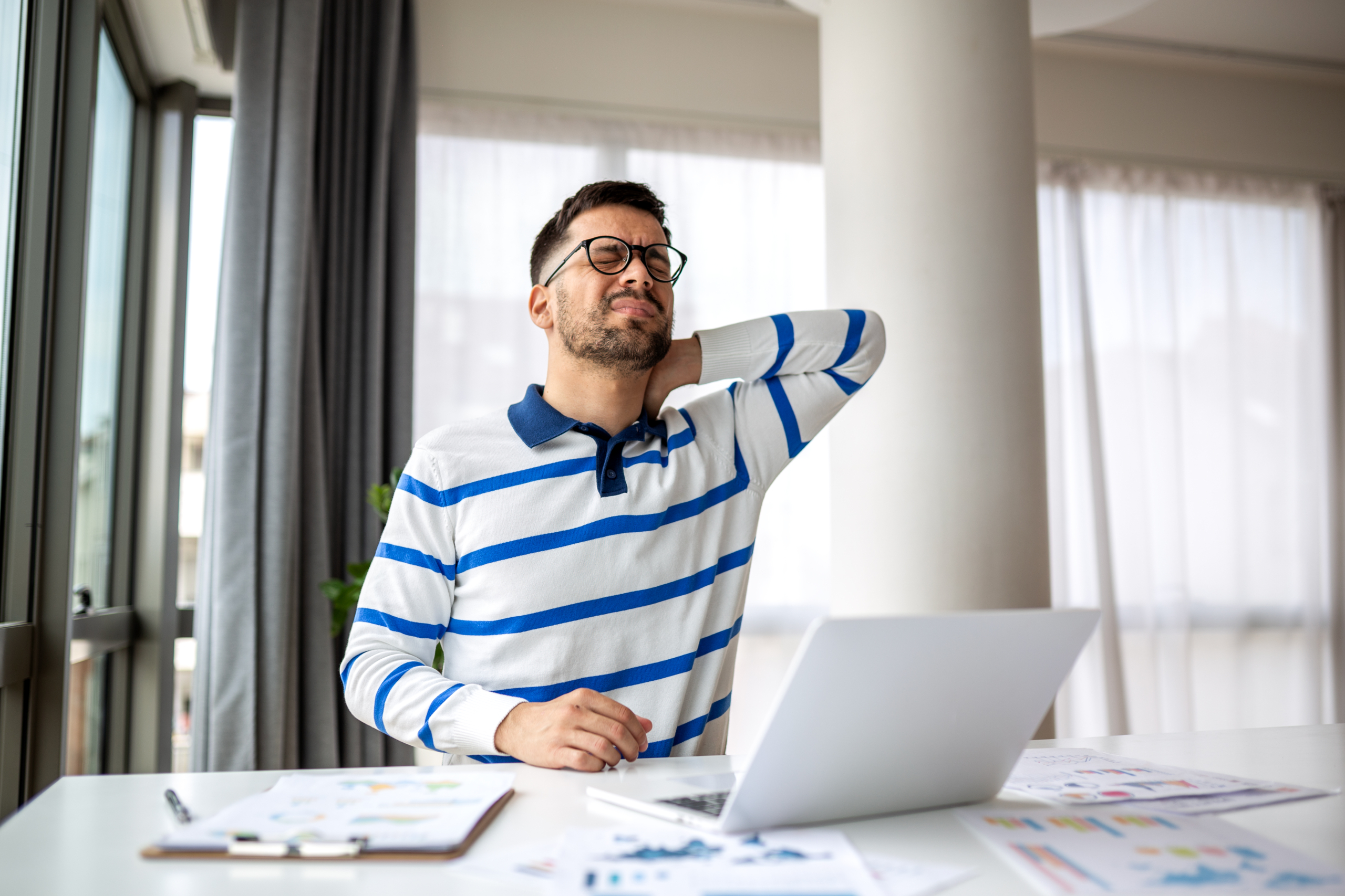 Man doing Self-Massage on her neck and shoulders at her desk