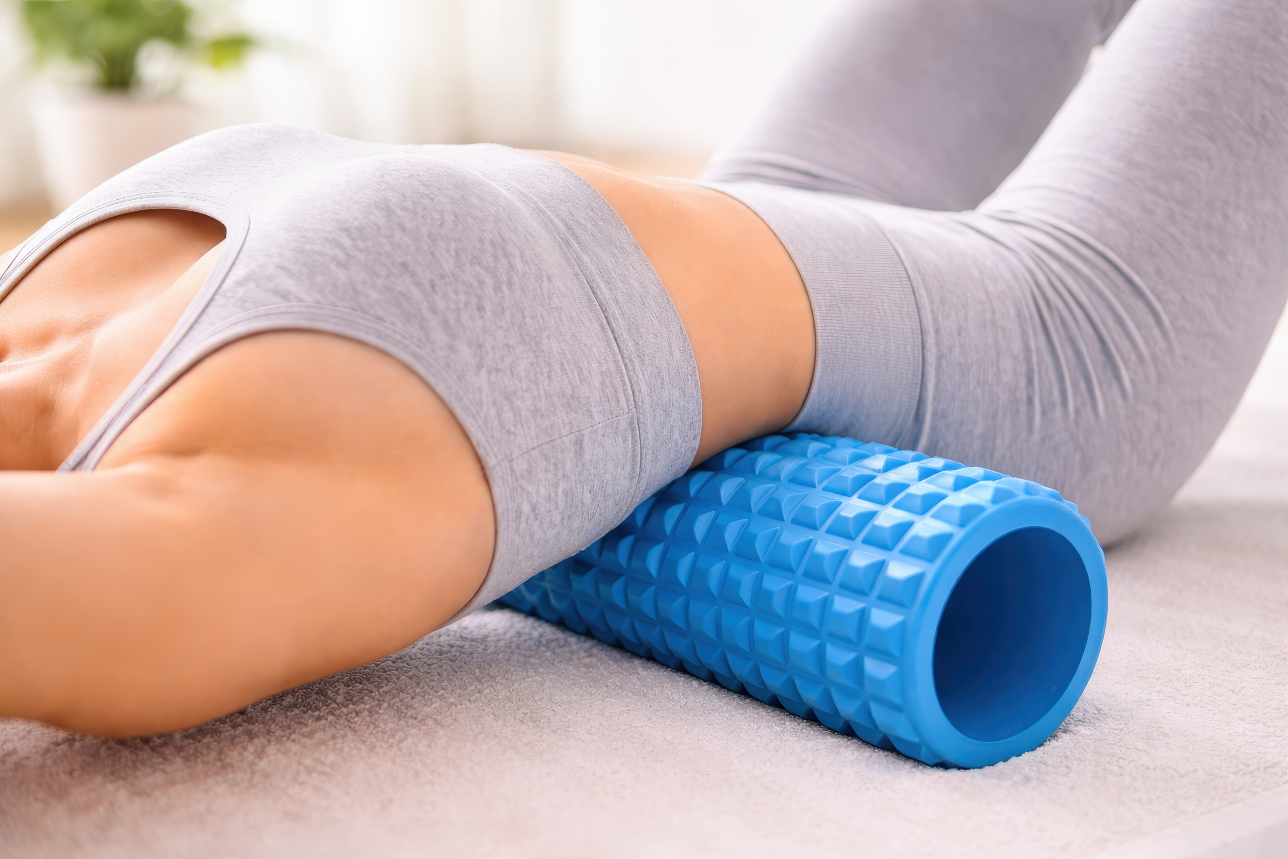 woman using foam roller for back pain relief at home