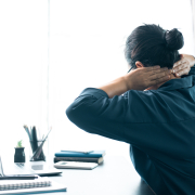 Office worker with rounded shoulders considering a back stretcher posture corrector
