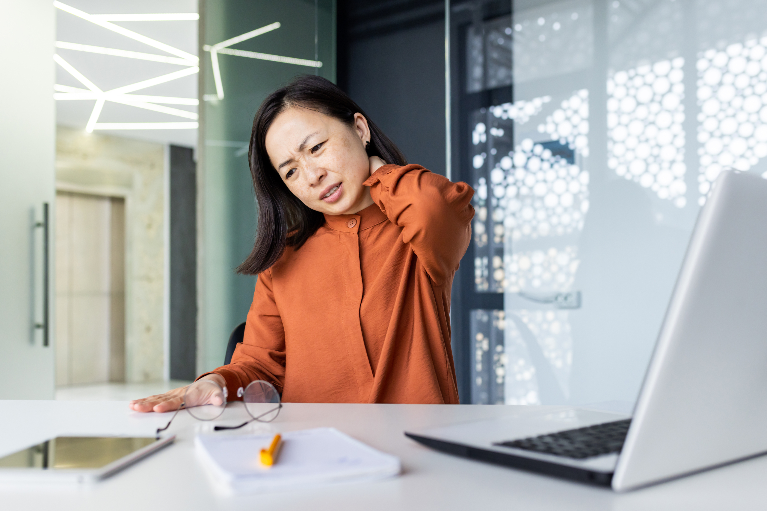 Office worker with stiff neck exploring the heated neck stretcher benefits