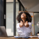 Office worker gripping a stiff neck before trying a neck stretcher for neck pain relief