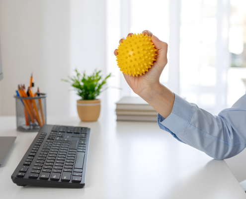 Person using the benefits of vibrating massage ball therapy on a tense shoulder