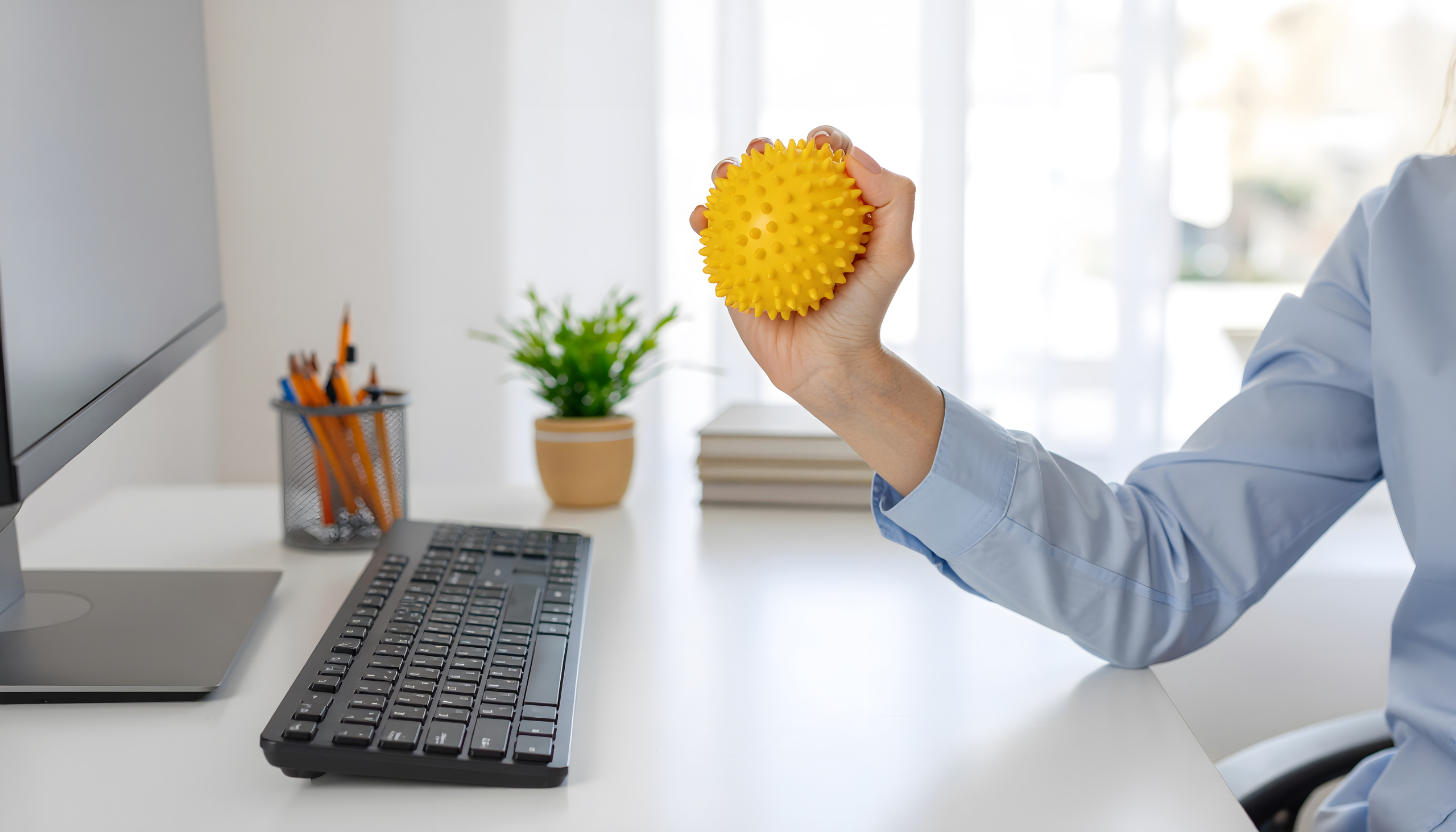 Person using the benefits of vibrating massage ball therapy on a tense shoulder