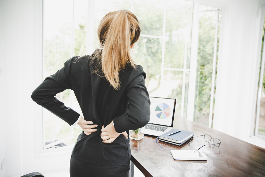office worker back stretch desk worker stretching therapy Office worker using desk worker stretching therapy to ease back stiffness at their desk