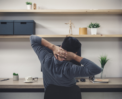 Slouched desk worker wondering does a posture corrector belt work for back ache