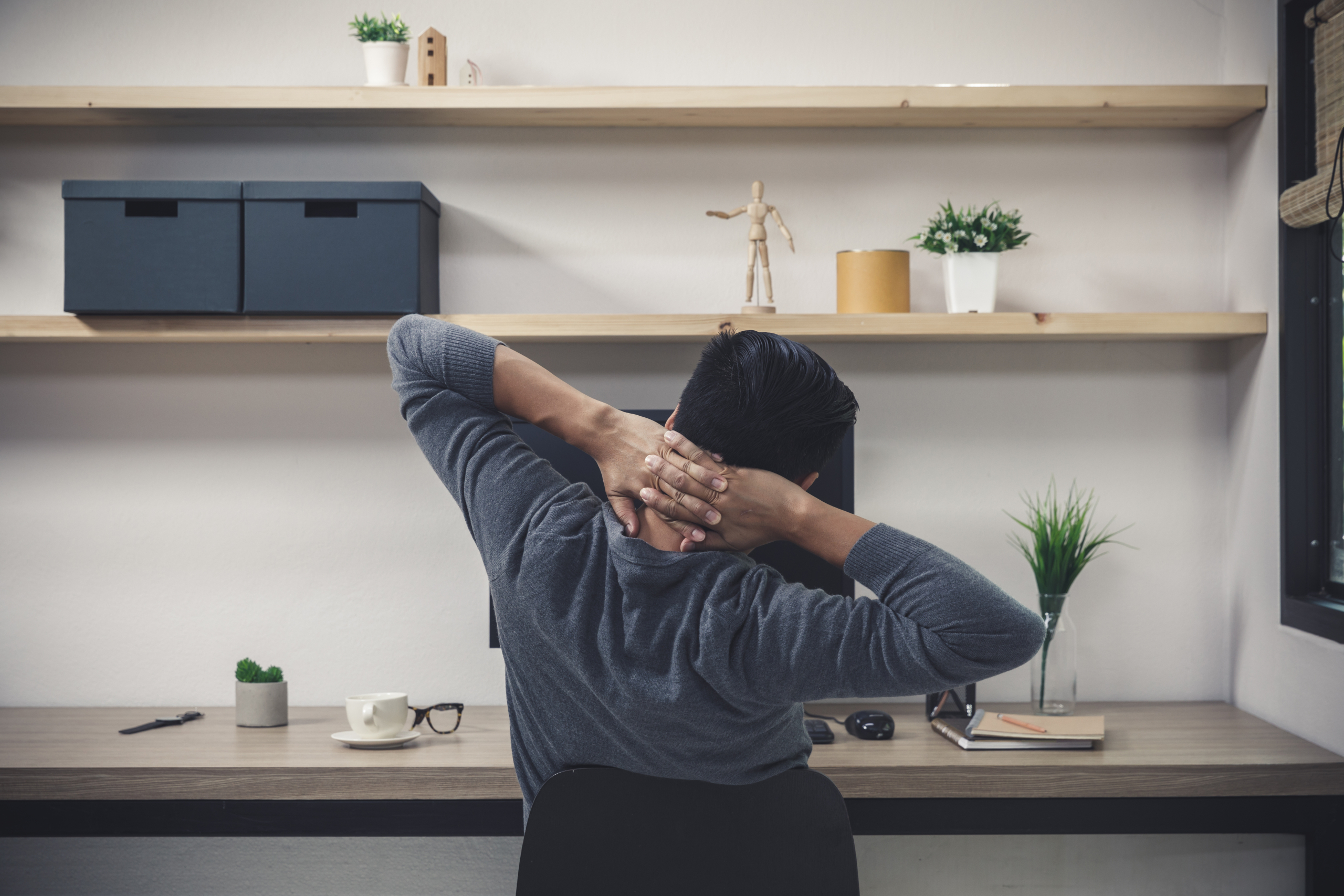 Slouched desk worker wondering does a posture corrector belt work for back ache