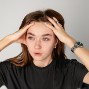 Woman experiencing migraine symptoms holding her head in pain