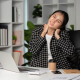 Desk worker rubbing a sore neck before trying a neck stretcher device